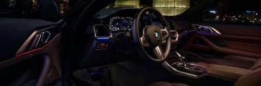 BMW 440i 'nin iç kısmı açık kapıdan görülebiliyor, geceleri Silezya Müzesi' nin arka planında duruyordu. Katowice, Polonya, 18 Şubat 2023