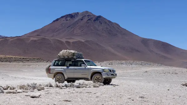 Bolivya, Nissan Devriyesi ve çölde bir dağın önünde durmak. Boliwia, Avoroa Ulusal Parkı, 14.10.2023