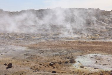 Hver, İzlanda. Namafjall 'ın eteğinde gerçek üstü, çıplak turuncu-kırmızı, jeotermal bir bölge. Fümeroller, çamur havuzları, buhar delikleriyle dolu. 1. Otoyol 'da. Namaskard Hver olarak da bilinir..