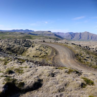 Lavların arasındaki toprak yolun manzarası. Helgafelveit, İzlanda.