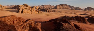 Wadi Rum, Ürdün 'deki çöl manzarası. Sabah ışığında kayalık dağlar ve kum vadileri. Vahşi doğada doğal jeolojik oluşumlar