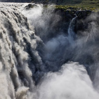 İzlanda 'da Dettifoss şelalesi. İzlanda 'da güçlü bir su akıntısı kanyona düşüyor. Şelaleden yükselen sis ve sprey. Doğal güç ve doğal güzellik.