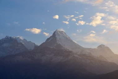 Güneş batmaya başladığında Poon Hill 'den gelen büyüleyici Himalaya manzarasına hayranlık duyan ziyaretçiler, karlı tepeler ve dalgalı vadilere sıcak bir parıltı saçıyor..