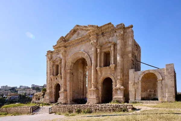 Ziyaretçiler Ürdün 'ün Jerash kentindeki antik bir Roma anıtı olan Hadrian Kemeri' nin ihtişamını keşfediyorlar. Site, güneşli bir günde mimari ve tarihsel önemi karmaşık şekilde sergiliyor..