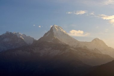 Görkemli Güney Annapurna zirvesi parlayan gökyüzüne karşı yükseliyor, Poon Hill, Nepal 'de sakin bir gündoğumu sırasında Himalayaların güzelliğini gözler önüne seriyor.
