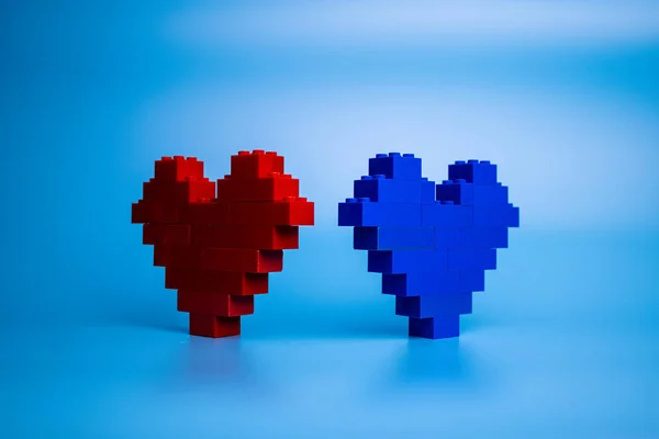 Plastik yapı taşlarından yapılmış kırmızı ve mavi kalpler, erkek ve kadın bağlantı sembolü