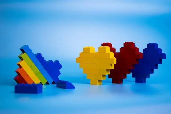 Renkli kalpler plastik yapı taşları kırık gökkuşağı kalbinin karşısında duruyor.