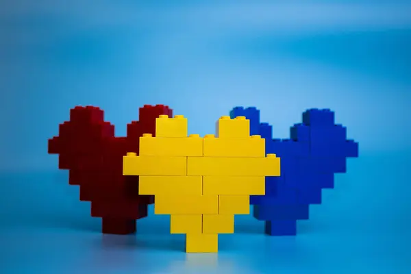 Sarı, mavi, plastik yapı taşlarından yapılmış kırmızı kalpler, birlik ve bağlantı sembolü