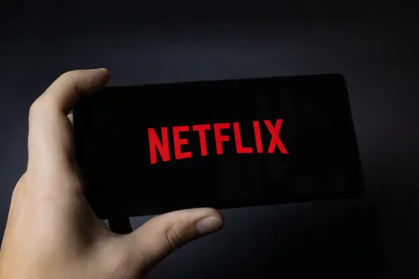 Elinde Netflix logosu olan bir akıllı telefon vardı.