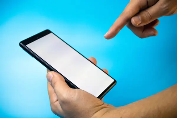 Mavi arkaplanda boş ekranı olan akıllı telefonu tut, jesti tıkla