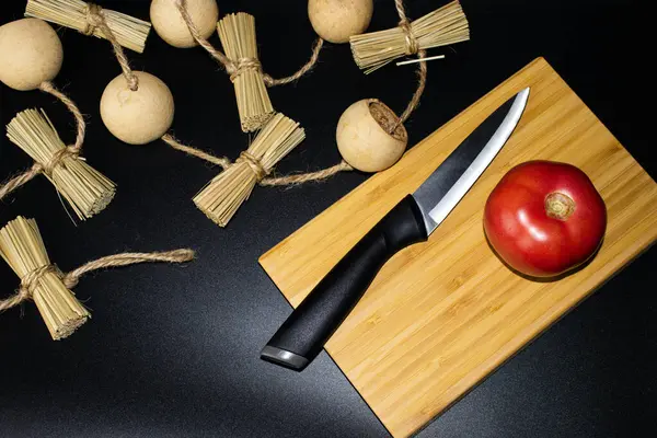 Tahtada taze domates, bıçakla kesme tahtası, arka planda saman.