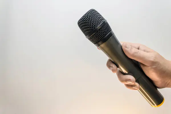 Bir mikrofon tutarak, beyaz-gri arka plan