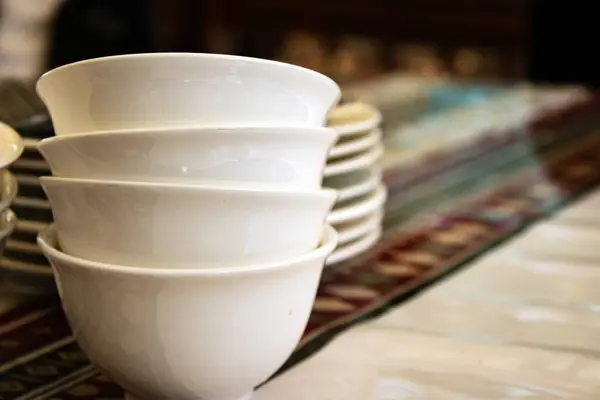 Güzel bir doğu masasında beyaz çay kaseleri.