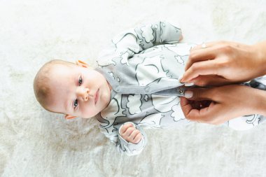 Bebek yalancı çocuk afişi. Beyaz yatakta yatan mutlu, tatlı bir kız bebek. Yatakta yatan sevimli küçük çocuk. Çocukluk banyosu kavramı