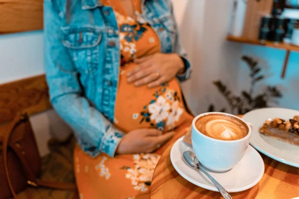 Pregnant woman drink coffee. Lifestyle morning with happy pregnancy girl drink espresso coffee. Concept for coffee product advertising