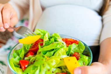 Pregnancy eating healthy salad. Happy pregnant woman eating nutrition food. People lifestyle food concept