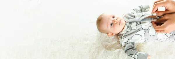 stock image Baby cute child banner. Happy cute baby kid girl lying on white bed background. Light background. Little child. Serious emotion