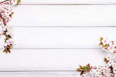 Arka plandaki bahar masası. Çiçekler ve Nisan çiçekleri tahta üzerinde olsun. Sancak olarak, arka planda çiçek açan kiraz dalları. Boşluğu kopyala
