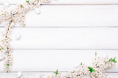 Easter background wood. Sakura blossom flower, white happy easter eggs on wood spring background. Easter design. Top view. Flat lay