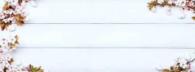 Easter eggs background. May flowers, white happy easter egg on wooden spring background. Easter card banner. Flat lay