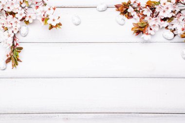 Paskalya yumurtaları. Mayıs çiçekleri, beyaz mutlu paskalya yumurtası ahşap bahar arka planında. Paskalya kartı. Düz yatıyordu