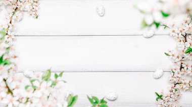 Paskalya düzlüğü. Kiraz ağacı çiçeği, beyaz mutlu paskalya yumurtaları ahşap bahar arka planında. İlkbahar konsepti