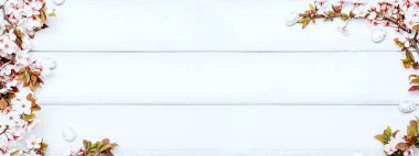 Paskalya bayrağı. Kiraz ağacı çiçeği, beyaz mutlu paskalya yumurtaları ahşap bahar arka planında. İlkbahar konsepti