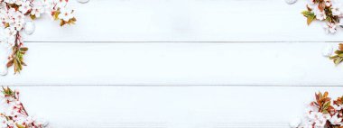 Easter eggs background. May flowers, white happy easter egg on wooden spring background. Easter card banner. Flat lay