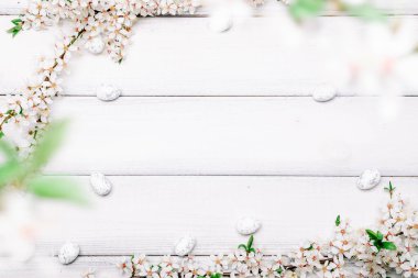 Paskalya düzlüğü. Kiraz ağacı çiçeği, beyaz mutlu paskalya yumurtaları ahşap bahar arka planında. İlkbahar konsepti