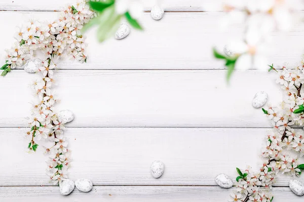 Easter spring background. Sakura flower, white happy easter egg on wooden spring background. Easter wallpaper. Spring holiday concept