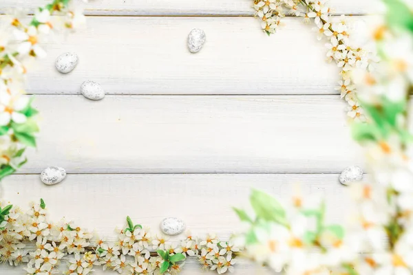 Easter white background. Spring flower border, white happy easter egg on wooden spring background. Easter card. Flat lay