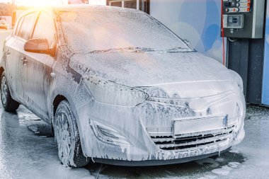 Araba yıkama. Araba temizleme sabunu köpüğü. Püskürtme baloncukları Islak ışık