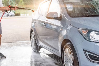 Araba yıkama köpükleri. Sabun köpüğü su sıçraması. Aracın dışı ıslak ve parlak.