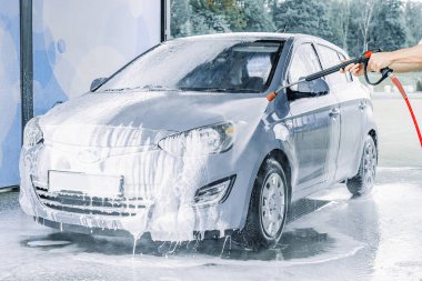 Araba yıkama köpükleri. Sabun köpüğü su sıçraması. Aracın dışı ıslak ve parlak.