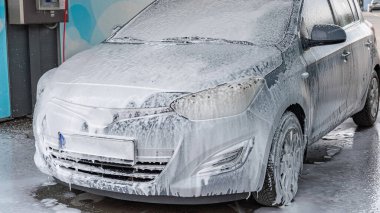 Araba yıkama. Araba temizleme köpüğü sabun köpükleri. Sprey su aracı ıslak parlıyor.