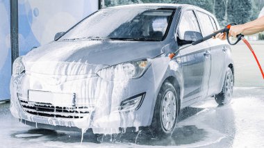 Araba yıkama köpükleri. Sabun köpüğü su sıçraması. Aracın dışı ıslak ve parlak.