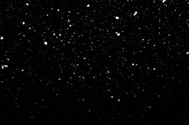 Falling snow freeze motion in the dark sky. Texture isolated on black background. Perfect for white snowflakes overlay, winter abstract clipart