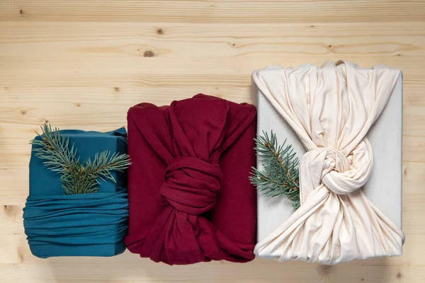潮流零浪费礼物包装 可持续设计概念 三份木制背景的面料圣诞礼物 平躺在床上 — 图库照片
