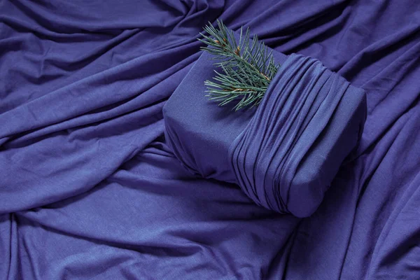 潮流零浪费礼物包装 可持续设计概念 用紫色背景的织物和褶皱做成的圣诞礼物 图库图片