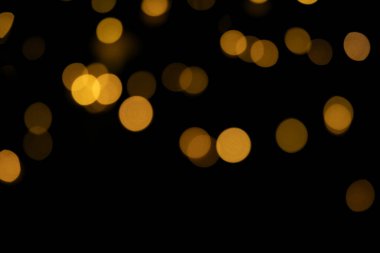 Bokeh altın ışıklar arka planı. Bulanık ışıklar siyah bir arkaplanda şenlik çelengi