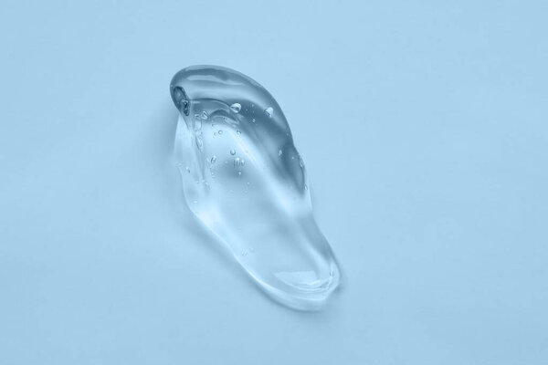 Косметический прозрачный гель на синем фоне. средства гигиены кожи крупным планом