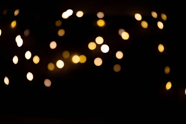 Bokeh金光闪闪 黑色背景下的圣诞节庆花环灯火辉煌 图库照片