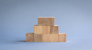 Ten wooden blocks stacked, on blue background.