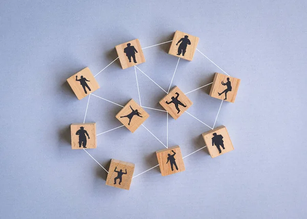 Wooden blocks with people icon on blue background. Team or human resources concept.