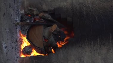 Wood burning slowly inside a charcoal kiln. 