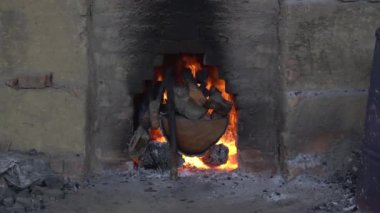 Wood burning slowly inside a charcoal kiln. 