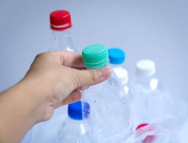 Şişelerle dolu plastik bir torbanın içine plastik bir şişe koymak. Geri dönüşüm veya çöp konsepti.