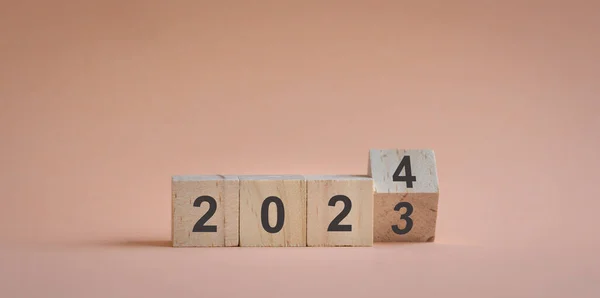 Wood cubes or blocks on table, turn of year from 2023 to 2024.