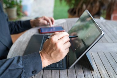 İşadamı stil kalemini kullanarak tablet üzerinde çalışıyor. Ev ortamı.