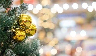 Ağaçta altın toplar ve bokeh arkaplanlı Noel süslemeleri. Boşluğu kopyala.